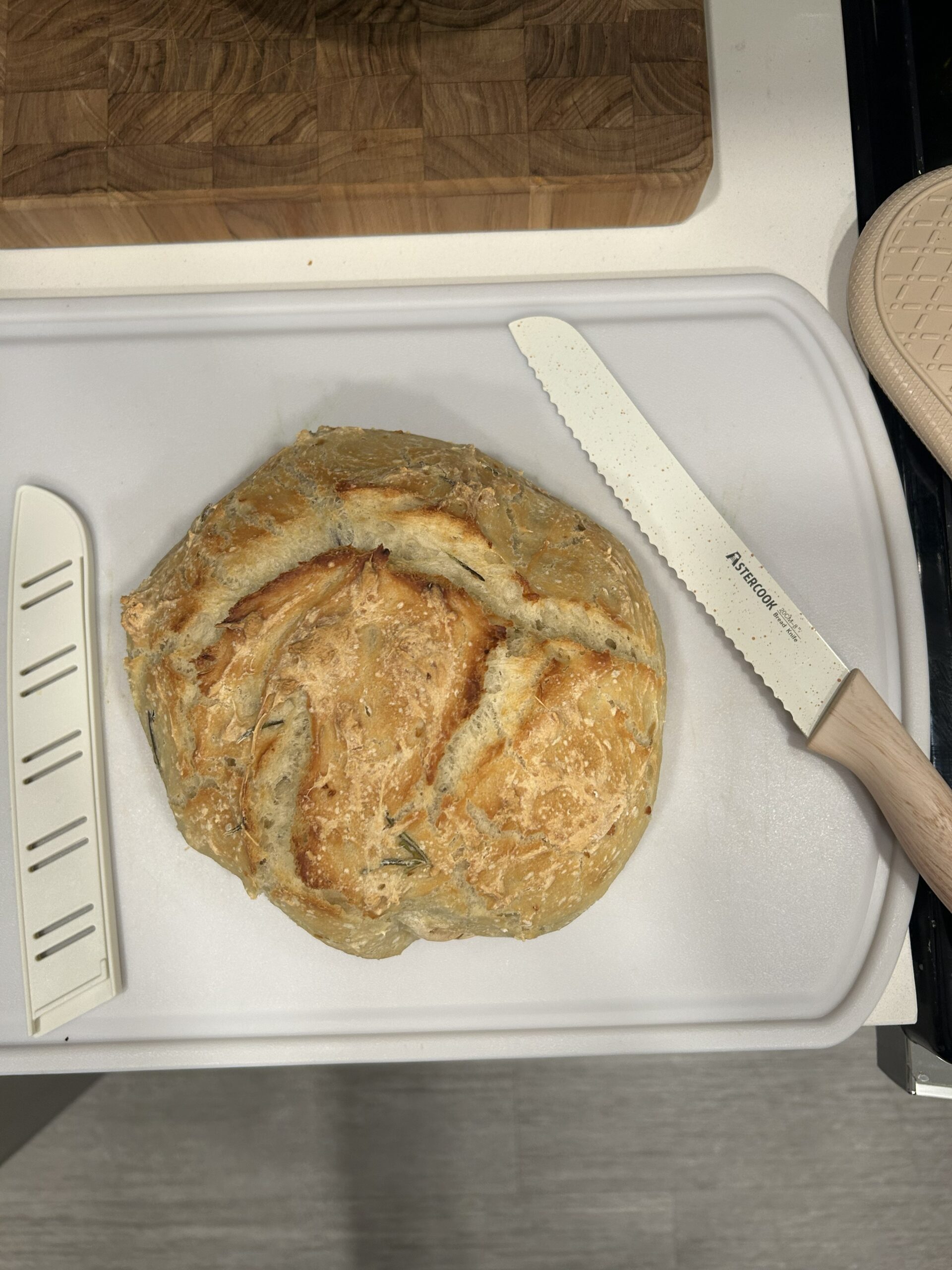 Homemade rosemary and garlic round loaf of bread on cutting board