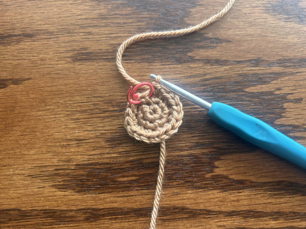 crochet hook and brown yarn showing round 3 of the crochet pattern