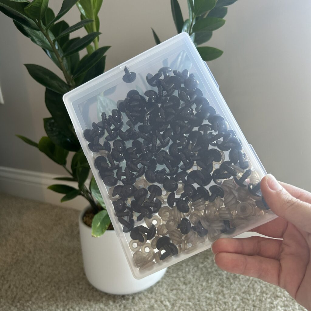 Hand holding a box of black safety eyes