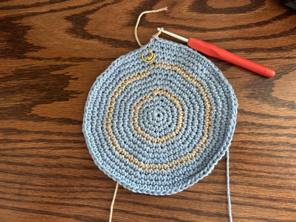 Last crown row of the top of the bucket hat worked in blue cotton yarn before working the straight body rounds