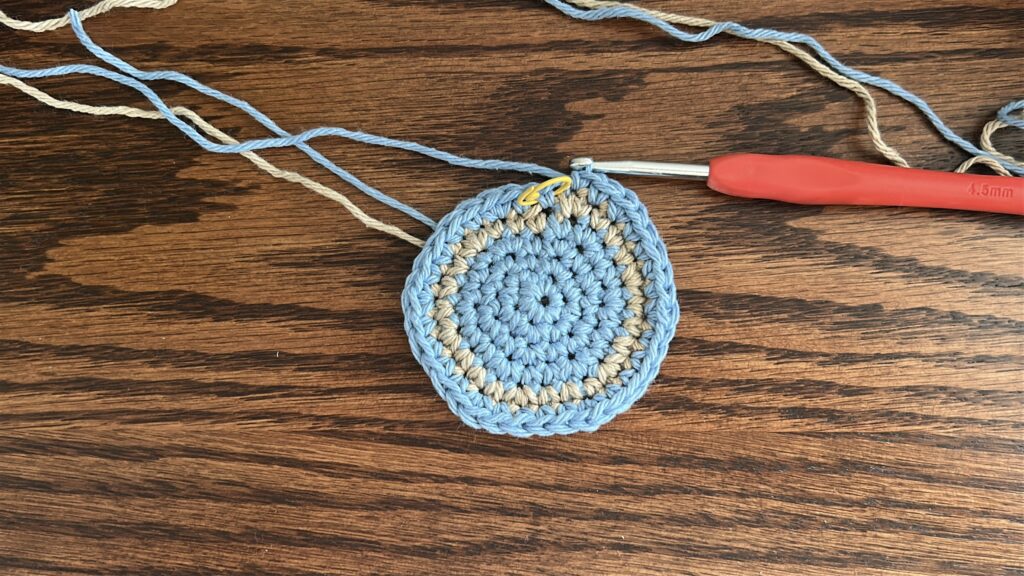 Striped crochet bucket hat after first stripe with blue and tan cotton yarn